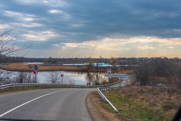 road in front of the village of Aleksandrovskoye, pond and fields on a sunny day of snowless winter in the south of Russia