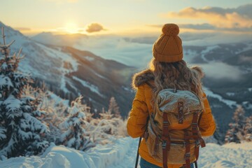 A brave woman braves the freezing winter sky as she stands in awe of the majestic mountain range, clad in a vibrant yellow jacket and hat, ready for an adventurous hike through the snowy outdoors