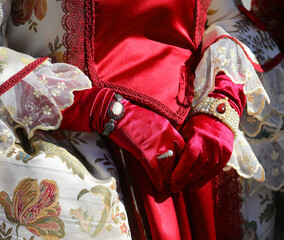 hands of woman with historical dress with red gloves during the celebrations