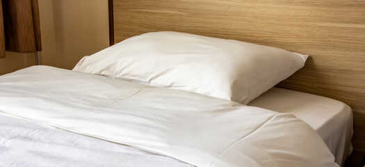 Soft pillow on a comfortable wood bed. Bedroom Interior. Banner view