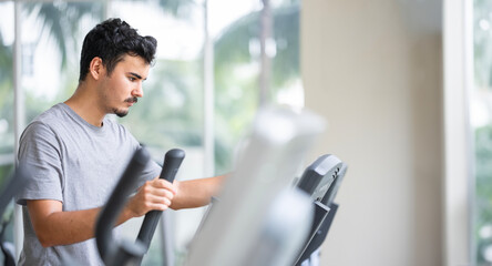 Focused individual using a cardio machine, demonstrating the dedication and intensity that goes into a healthy lifestyle and fitness routine. Dedication to cardio and fitness concept.