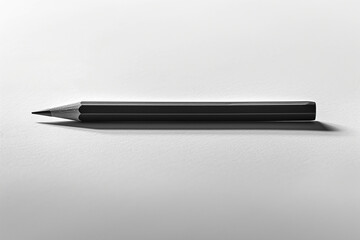A pencil placed on a white sheet of paper is a black and white style image.
