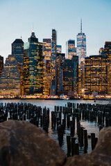 Manhattan skyline seen from the Brooklyn Pier with wooden breakwaters in the foreground at night