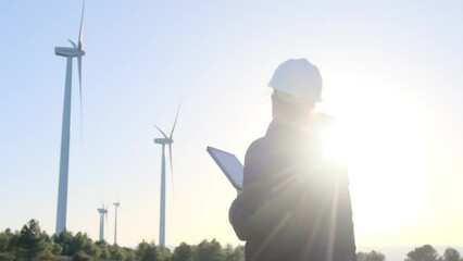 Confident female engineer ensures efficient, safe renewable energy at sunset. Innovative teamwork in manufacturing, led by a businesswoman, focuses on sustainable solutions. Diverse workforce .