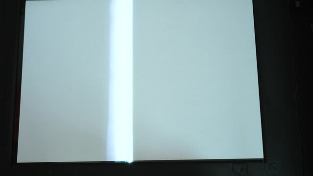 Process of scanning a document. Copier scanning document. Scanning white sheet of paper. Checking scanner operation with open cover 