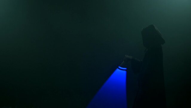 Young man in cosplay costume with lightsaber battle on black background in smoke and rain, 4k slow motion video filmed on 8k camera nikon z9