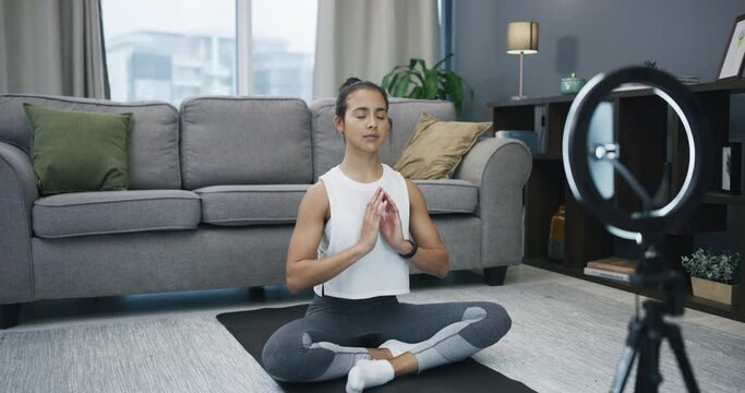 Yoga, meditate and phone recording woman, social media influencer or yogi streaming zen relief routine. Ring light, cellphone and content creator filming calm video, home meditation or chakra healing