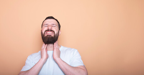 man with a beard is smiling and holding his neck. Concept of happiness and contentment