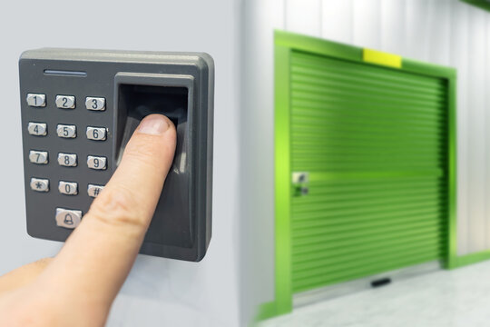 Electronic lock for entering warehouse. Fingerprint scanner near green gate. Code lock for access to storage. Warehouse security technology. Fingerprint scanning. Fingerprint scanner at storage unit