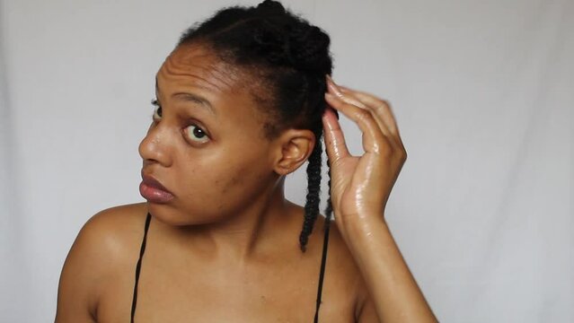 Black woman untwisting her natural 4c hair on a white background