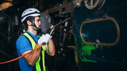 Industrial engineers inspect and perform maintenance on the machines at factory machines. Teamwork...