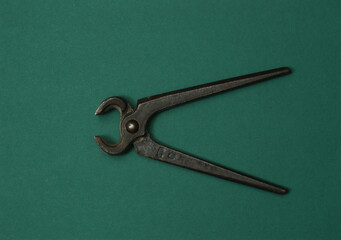 Vintage cutting pliers in action on green color background. Loopable stop motion animation. 4K top view. DIY video concept.