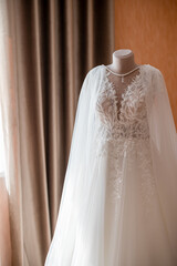 A delicate ivory tulle wedding dress without sleeves on a mannequin