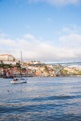 Obraz premium A yacht on the Douro River in Porto, in front of the Luís I Bridge