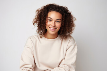 Fototapeta premium A photograph of a woman with curly hair sitting on a chair in a room.