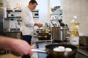Young chef is preparing food in a restaurant kitchen