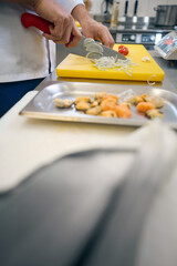 Man cuts vegetables on a yellow cutting board