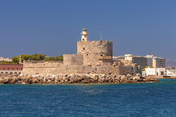 Old stone lighthouse at Fort St. Nicholas in Rhodes on a sunny day.