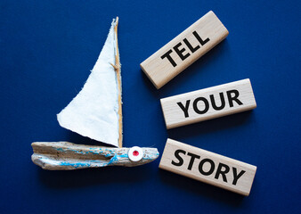 Tell your story symbol. Wooden blocks with words Tell your story. Beautiful deep blue background...