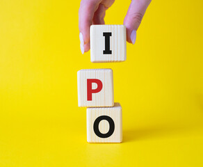 IPO- Initial Public Offering symbol. Concept word IPO on wooden cubes. Businessman hand. Beautiful...