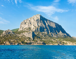 Fototapeta premium Summer rocky coastline on blue sky background (