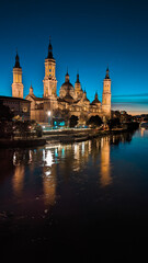 As the Sun Bids Farewell and the Ebro River Turns into a Mirror: The Enchantment of Sunset Facing the Iconic Basilica of Our Lady of the Pillar in Zaragoza