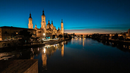 Obraz premium Amidst Golden Gleams and Coppery Shades: The Sunset by the Majestic Basilica of Our Lady of the Pillar, Emblem of Zaragoza