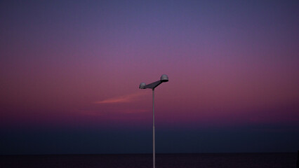 Calm shot of a light pole on the street, blue and purple colors