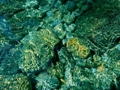 Underwater sea stones gravel pebbles in the clear water 