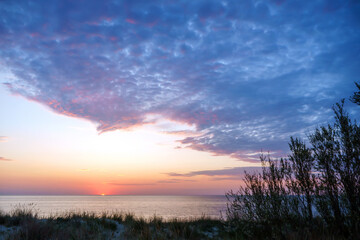 Sunset over the sea. Reflection of sunlight in the sea waves. The sky in the sunset rays. Baltic Sea.