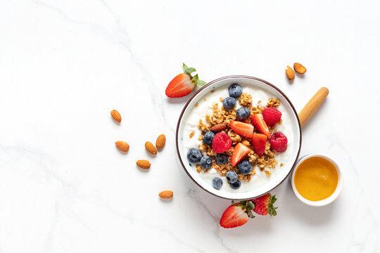 Healthy breakfast bowl with ingredients granola fruits Greek yogurt and berries top view. Weight loss, healthy lifestyle and eating concept