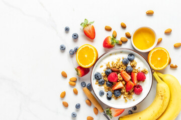 Healthy breakfast bowl with ingredients granola fruits Greek yogurt and berries top view. Weight...