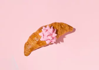 Fotobehang Fresh croissant decorated with pink gift bow, pastel background  © Biancaneve MoSt