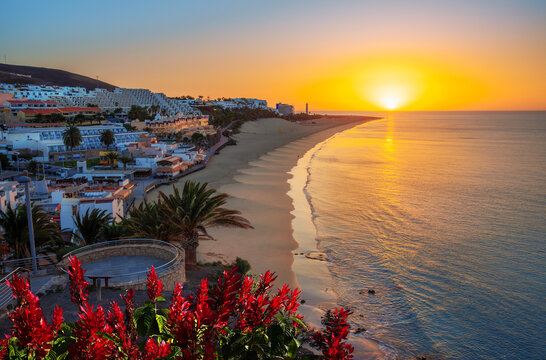 Beautiful sunrise on the coast of the Atlantic Ocean in the region of Jandia with the sun rising over Morro Jable beach on the island of Fuerteventura in Spain