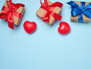  Gift box with red satin ribbon and bow on a blue background. Holiday background