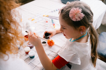 Little girl painting the egg , preparing for Easter at home