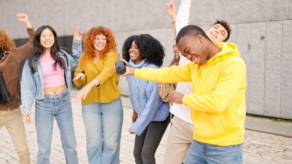 Multi-ethnic young friends dancing in the street
