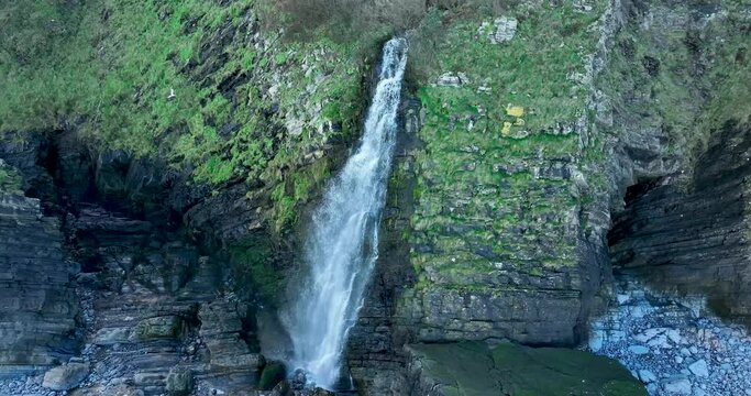 Waterfall. Jurassic Park. Devon, South of Great Britain. Cinematic drone flight