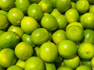 Tray of fresh limes on a market stall. Backgrounds.