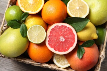 Different cut and whole citrus fruits on table, top view