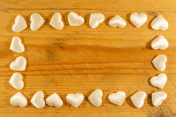Rectangle frame of soft little white hearts on shaved wood