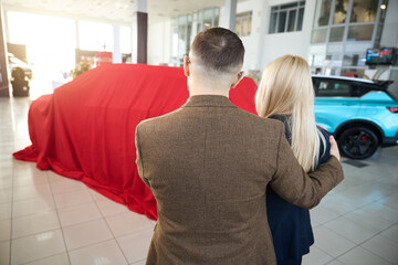 Two people looking at a car in a gift case