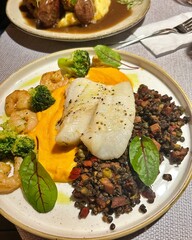plate with halibut, fish dish, lentils with bacon, shrimps, beetroot leaves, yellow pumpkin cream