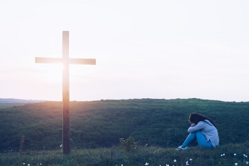 Prayer. Repentance. A woman is kneeling. Near the cross. Prayer of repentance. Christian faith....