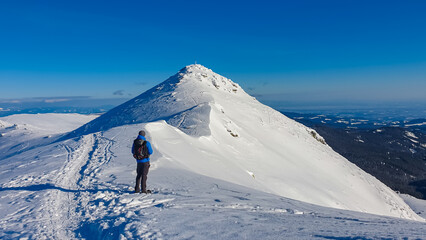 Man in snowshoes on snow covered mountains of Kor Alps, Lavanttal Alps, Carinthia Styria, Austria....