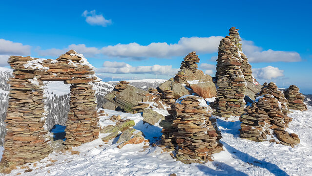 Snow covered massive unique stones display on mountain peak Steinmandl in Kor Alps, Lavanttal Alps, Carinthia Styria, Austria. Artistic stone constellation in Austrian Alps in winter. Ski touring path