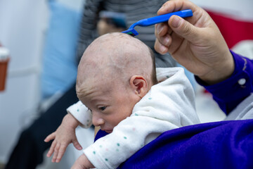 baby girl shaving her hair with sharp razor. shaving hair for 1 month