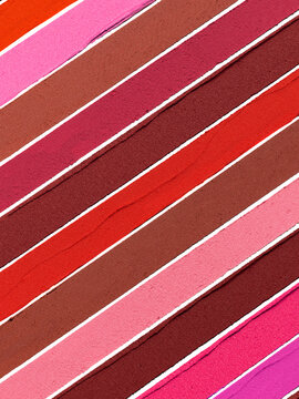 Pink red matte lipstick striped texture background composition. Cosmetic product smear smudge swatch