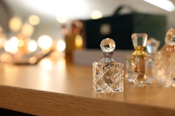 Beautiful perfume bottle on wooden table, space for text