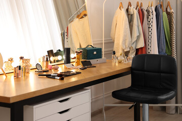 Makeup room. Stylish dressing table with mirror, chair and clothes rack